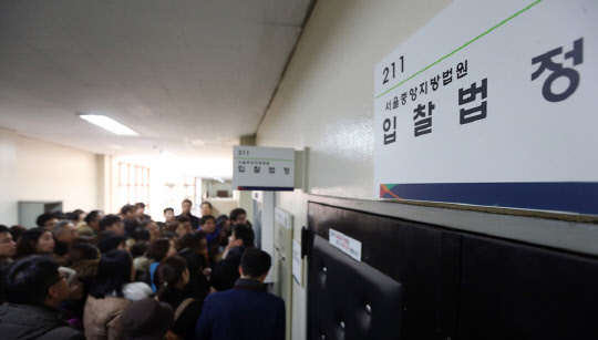 주택 시장의 열기가 법원 경매 시장까지 확대되고 있다. 비수기인 8월 낙찰가율과 응찰자 수가 일제히 상승했다. 지역별로 양극화가 심하므로 '묻지마 낙찰'은 삼가야 한다고 전문가들은 조언했다. 사진은 서울중앙지방법원 경매 입찰 법정 전경.   연합뉴스